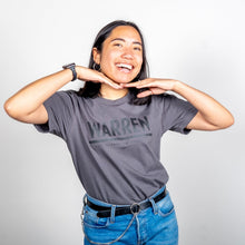 Load image into Gallery viewer, Warren Minimalist Unisex Asphalt T-shirt with Black Text on model smiling with hands under her chin. (1519734849645) (7433026207933)