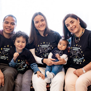 Grandmother, Mom, Dad, a young child and a baby seated on a couch all wearing the Pinky Promise design. (4170162405485) (7432140325053)