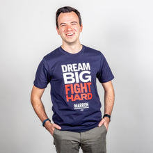 Load image into Gallery viewer, Dream Big, Fight Hard Unisex Navy T-shirt with White and Red Text. On model with hands in pockets. (1518922596461) (7432137736381)
